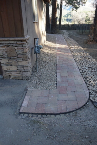Paver pathway connecting driveway to back deck, dry creek bed french drain, with cobble landscaping along house