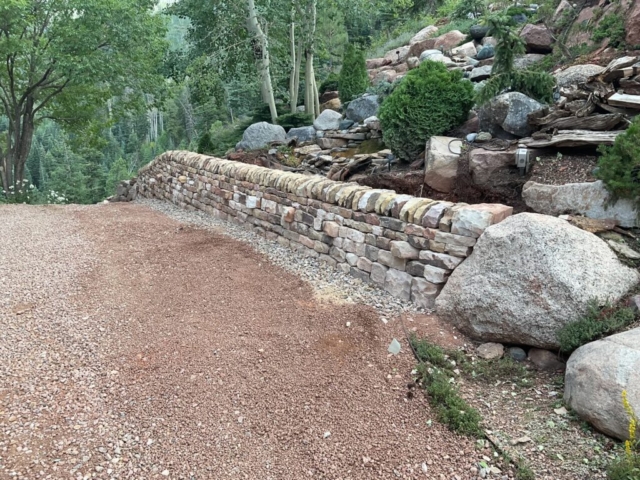 Sandstone traditional double face dry laid stone retaining wall with vertical copes and protruding through stones