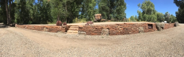 panoramic view of Traditional dry stone retaining wall used to retaing driveway. Custom staircase, art recesses and boulder accents integrated