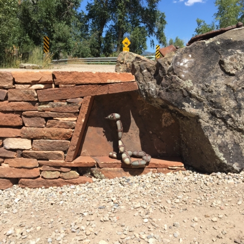 Custom designed stone retaining wall recess for art, natural stone lintel. Boulder art integrated