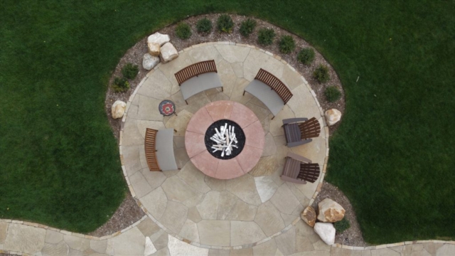 flagstone patio with stone borders and dry laid stone fire pit with custom cap and integrated utilities, boulder accents