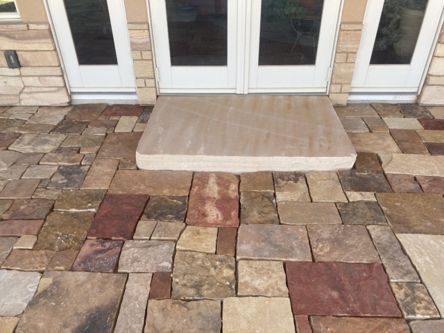 Dry laid natural stone paver patio and natural stone slab landing under doors