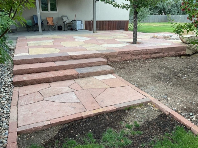 terraced flagstone patio with custom sandstone slab staircase with flagstone landing. stone borders also visible
