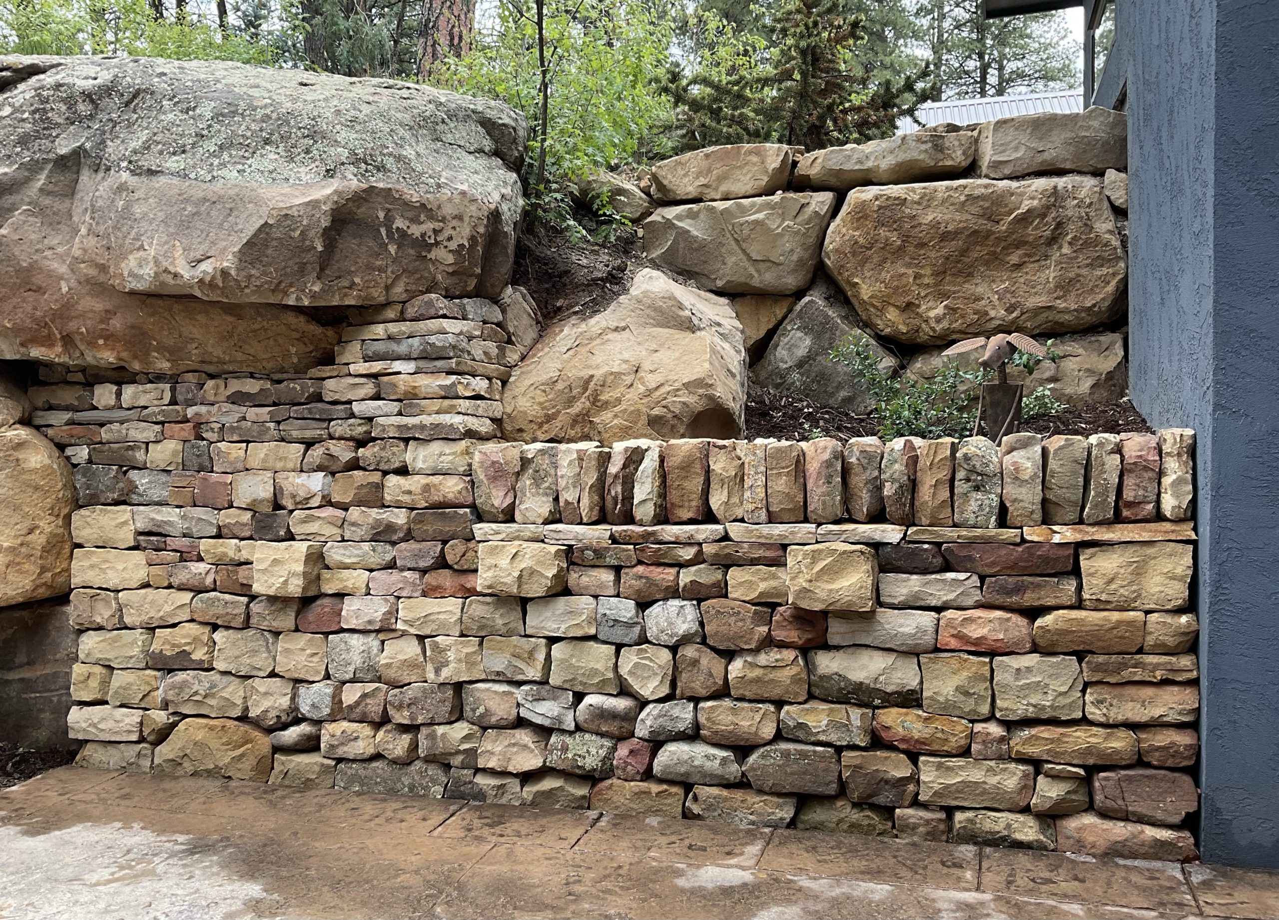 traditional dry stone retaining wall with through stones and vertical coping stones. boulder retaining wall also visible