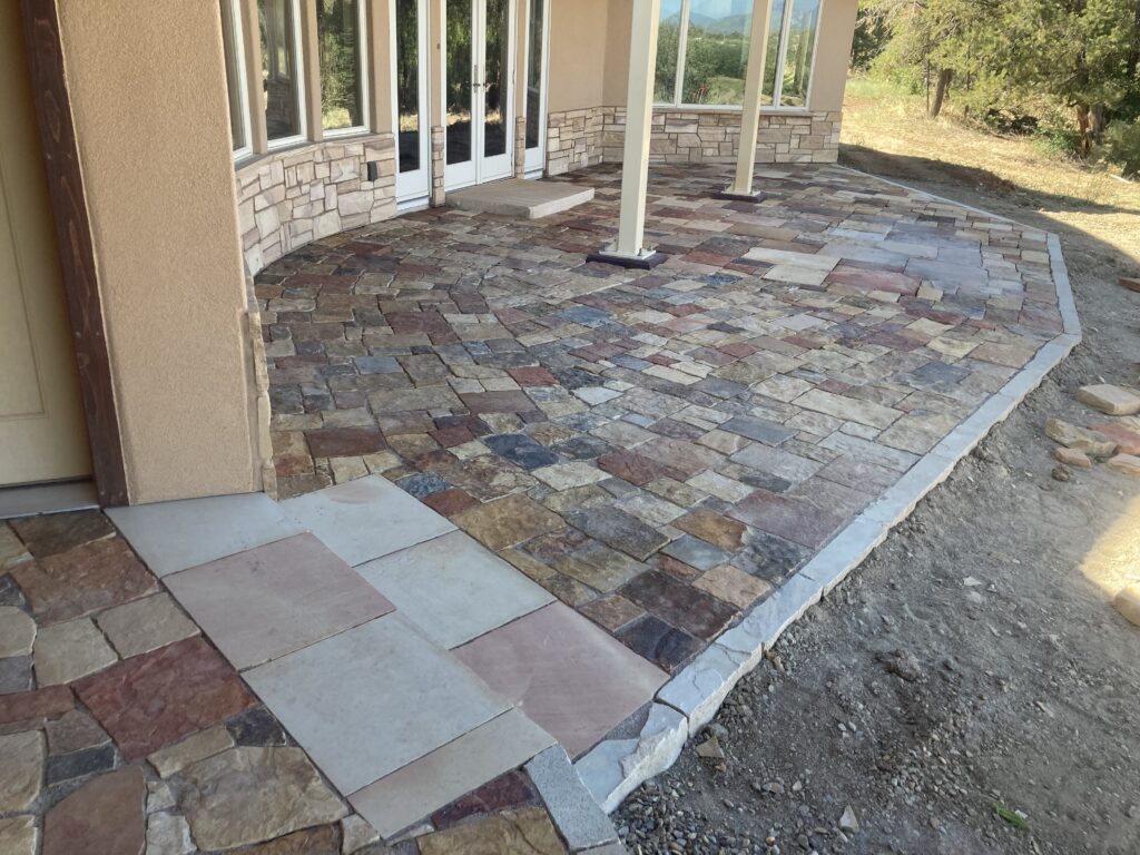 Natural stone dry laid pavers with stone borders, custom stone slab landing, and custom stone step